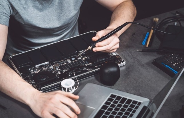 persona testeando componentes de un notebook al hacerle mantenimiento